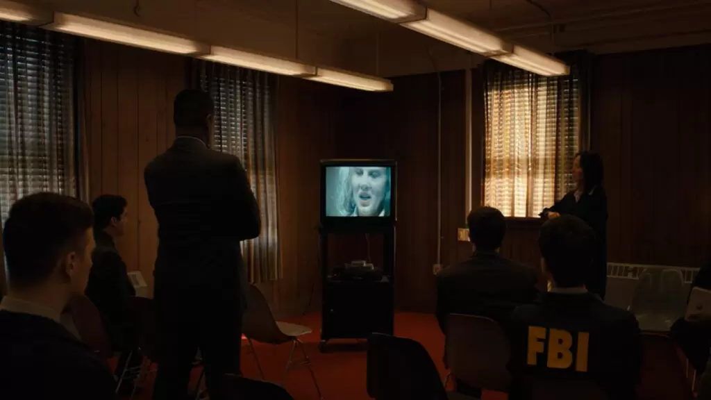(FBI reunido em uma sala, observando o depoimento do serial killer longlegs - Questão D