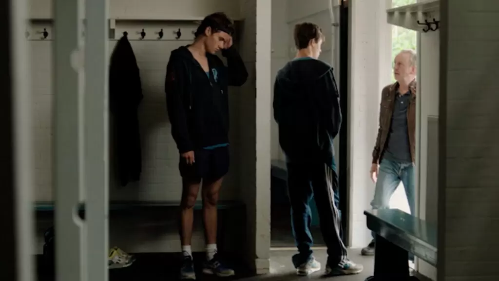 Boys (Jonges, 2014) | Sieger (Gijs Blom) falando com seu pai na porta do vestiário e Marc (Ko Zandvliet) atrás da coluna, para não ser visto | Questão D
